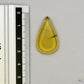 Cabochon en ambre jaune du Mexique, forme goutte, avec des inclusions naturelles et une finition polie. Présenté avec une règle pour référence