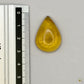 Cabochon en ambre jaune du Mexique, forme goutte, avec des inclusions naturelles et une finition polie. Présenté avec une règle pour référence