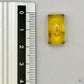 Cabochon en ambre jaune du Mexique, forme rectangulaire, avec des inclusions naturelles et une finition polie. Présenté avec une règle pour référence